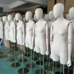 xintu factory batch production of standing female mannequins wrapped in beige linen fabric with adjustable wooden arms and brushed gold round bases
