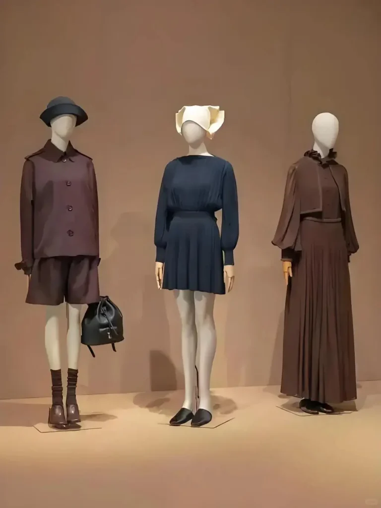 Vitrine du magasin Loro Piana avec trois mannequins femme en pied gainés de lin beige et bras articulés en bois