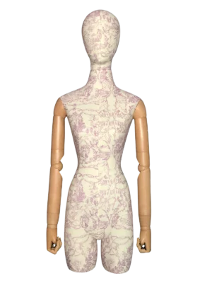 ภาพระยะใกล้ด้านหน้าของหุ่นจำลองหญิง XINTU ที่มีผ้าลายดอกไม้สีอ่อน หัวแบบนามธรรม และแขนไม้แบบขยับได้.