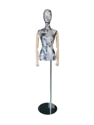 抽象的な頭部、花柄の布地、関節式の木製の腕、黒い丸い台座を備えた XINTU 女性胴体マネキン。.
