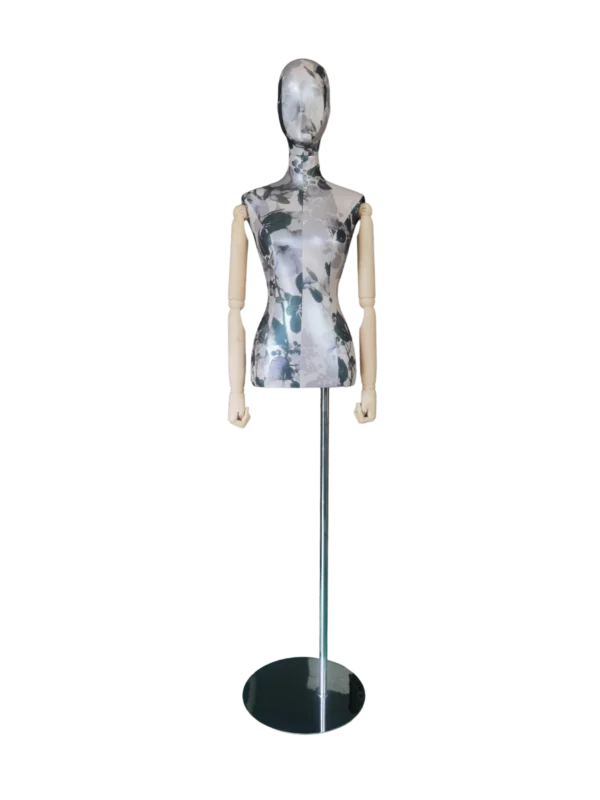 xintu-manichino-da-esposizione-in-tessuto-floreale-con-braccia-in-legno-snodate-e-base-in-metallo-rotonda-vista-frontale Manichino femminile XINTU con testa astratta, tessuto con motivo floreale, braccia articolate in legno e base rotonda nera.