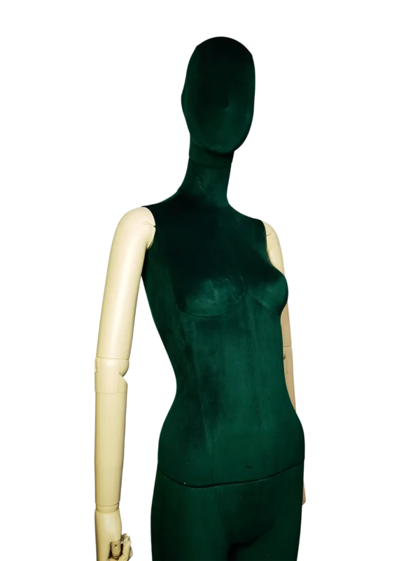 Primer plano en ángulo de un maniquí femenino XINTU, con cuerpo de terciopelo verde oscuro y cabeza abstracta, con brazos blancos ajustables que contrastan.