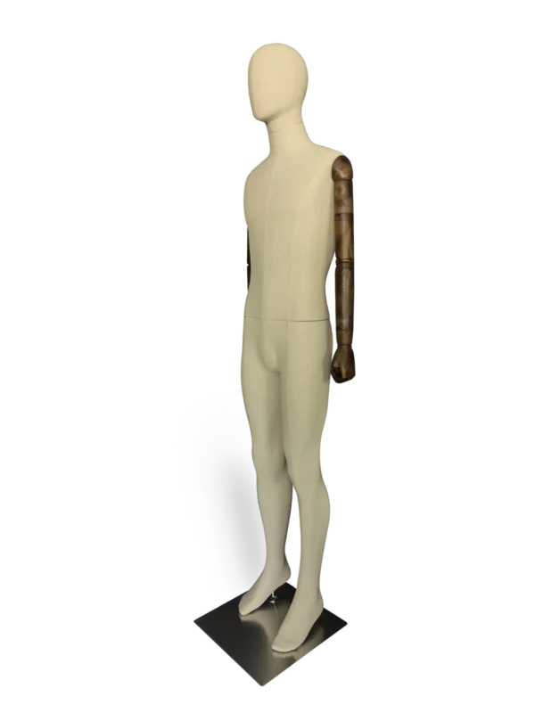 Angled view of a XINTU full-body male mannequin, covered in off-white linen-style fabric, with articulated dark wooden arms, standing on a dark brushed-metal square base.
