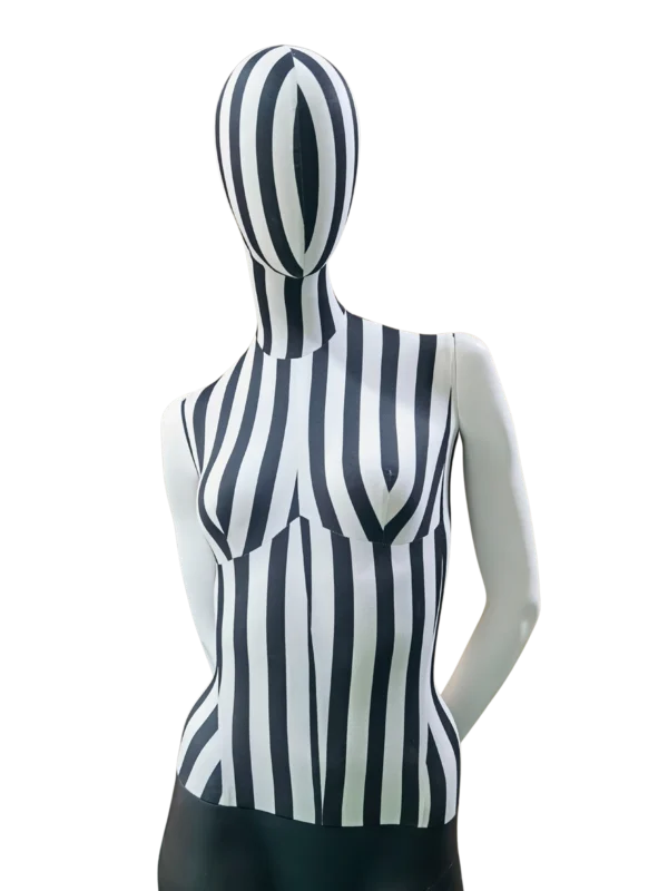 XINTU 女性人體模型的近景斜角視圖，其軀幹為黑白條紋布料，頭部為抽象設計，手臂為亮白色。.