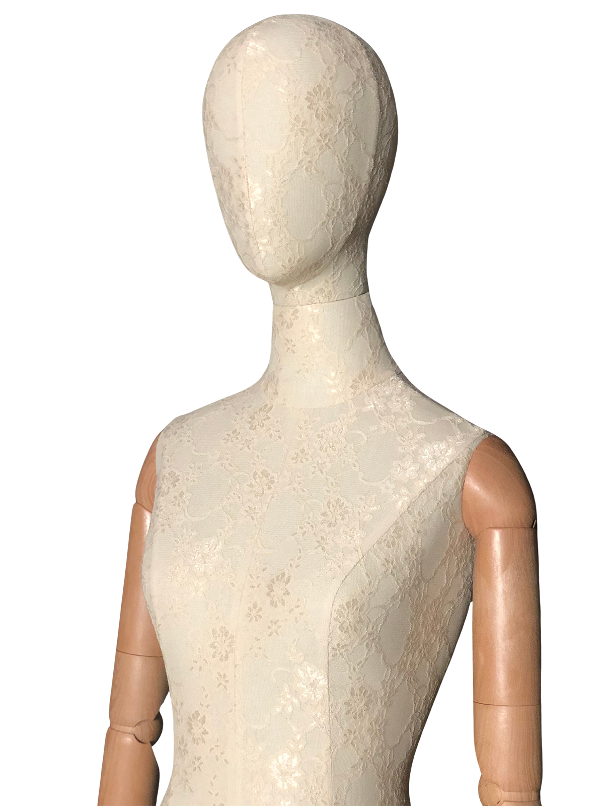 Primer plano frontal del torso de un maniquí femenino XINTU, cubierto de tela de encaje blanca, con una cabeza abstracta y brazos articulados de madera.