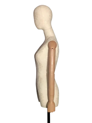 Perfil lateral de un torso de maniquí femenino XINTU, cubierto de tela de encaje blanca, con cabeza abstracta y brazos articulados de madera.