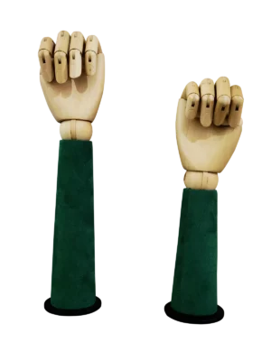 Vista frontal de dos manos de maniquí articuladas de madera XINTU, colocadas como puños, sobre soportes de exhibición de terciopelo verde oscuro.