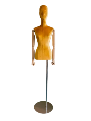 มุมมองด้านหน้าของหุ่นจำลองลำตัวหญิงของ XINTU หุ้มด้วยกำมะหยี่สีเหลือง มีหัวแบบนามธรรม แขนไม้ และฐานโลหะกลม.