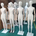 Four linen fabric-covered full-body female mannequins with articulated wooden arms at the XINTU factory in Shenzhen